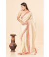 tissue silk saree in a soft golden hue featuring delicate red border 