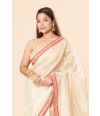 tissue silk saree in a soft golden hue featuring delicate red border 